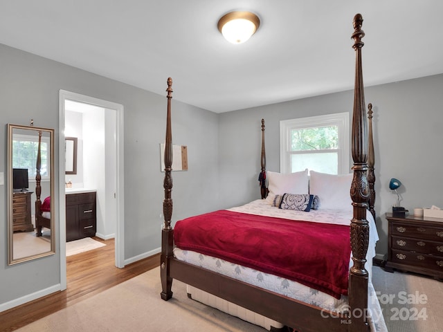 bedroom featuring wood-type flooring and ensuite bathroom