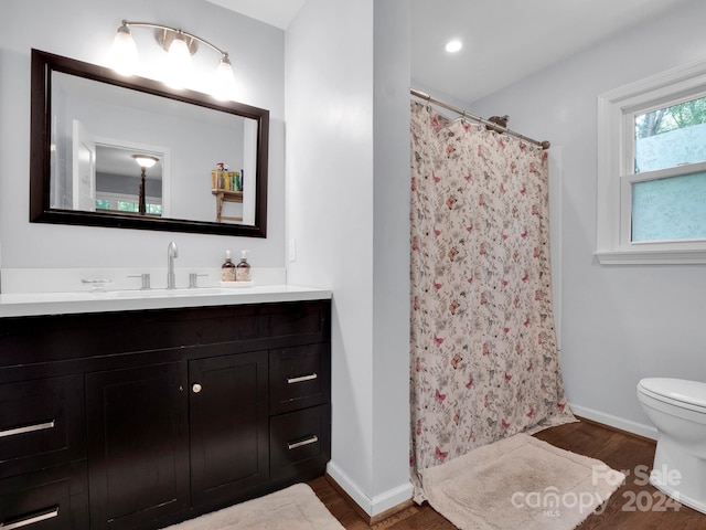 bathroom with a shower with shower curtain, vanity, toilet, and hardwood / wood-style flooring