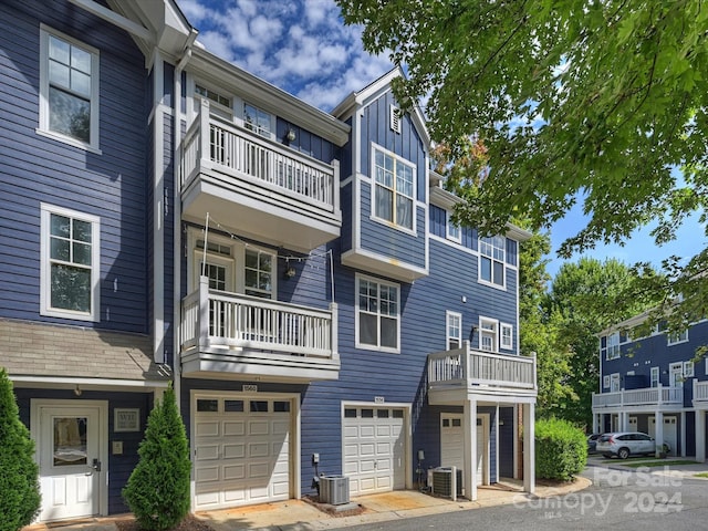 view of front of home featuring a garage, central AC, and a balcony