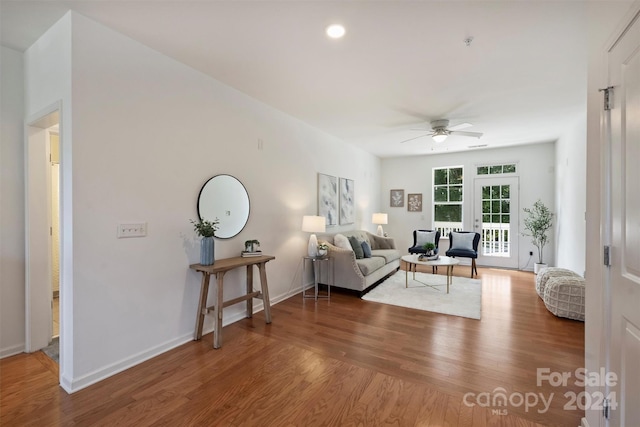 living room with ceiling fan and dark hardwood / wood-style floors