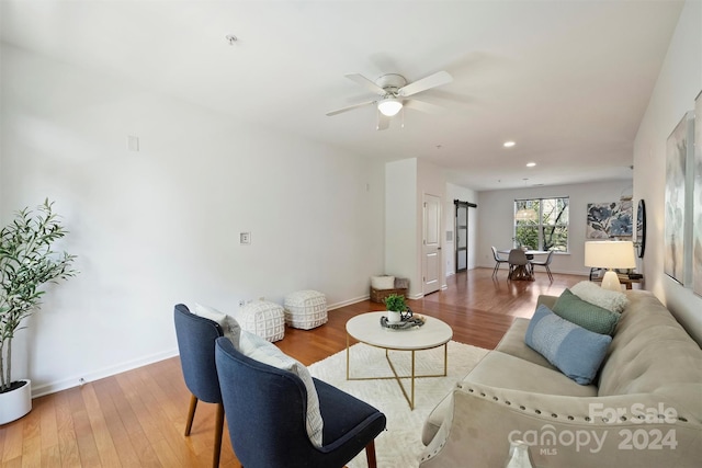 living room featuring ceiling fan and hardwood / wood-style flooring