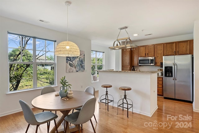 kitchen featuring plenty of natural light, decorative light fixtures, and appliances with stainless steel finishes