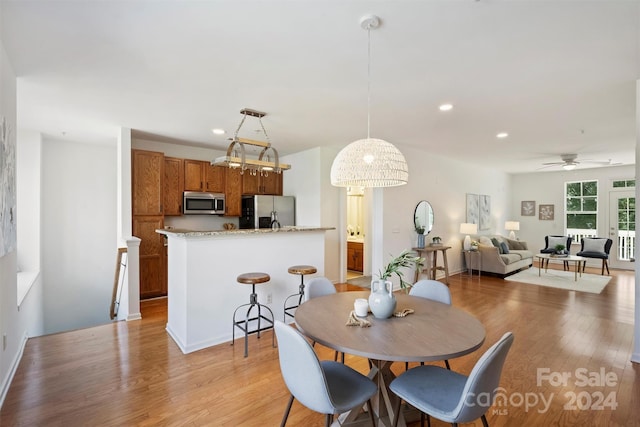 dining room with light hardwood / wood-style flooring and ceiling fan