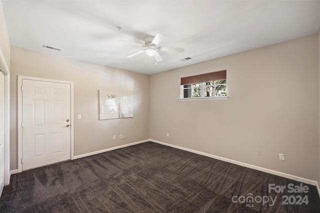 carpeted spare room featuring ceiling fan