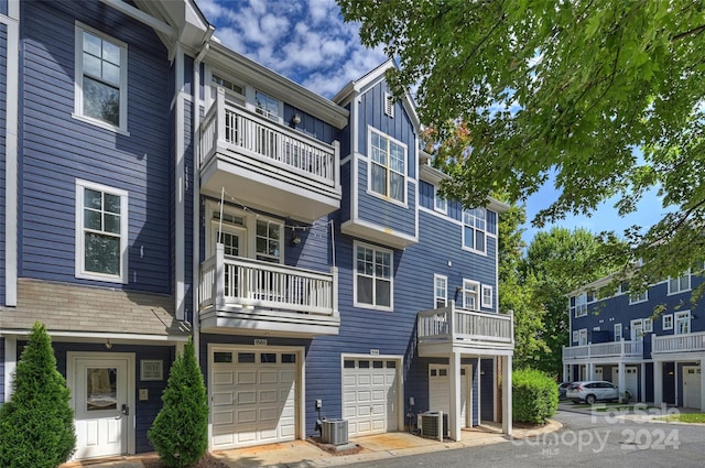 view of property featuring a garage and central AC unit