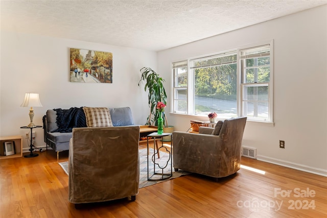 living area featuring hardwood / wood-style floors and a textured ceiling