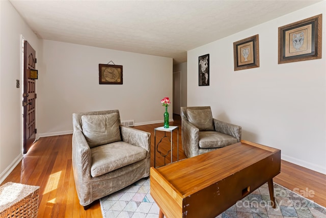 sitting room featuring light wood-type flooring and a textured ceiling