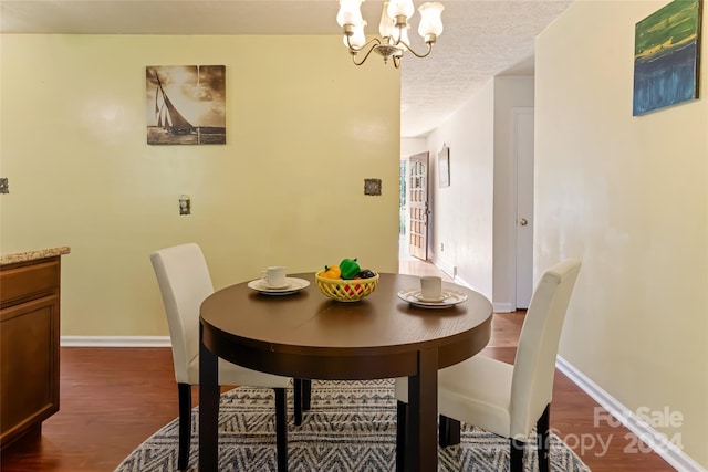 dining space with wood-type flooring and an inviting chandelier