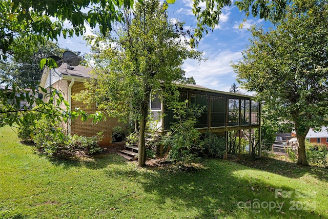 back of house featuring a lawn and a sunroom