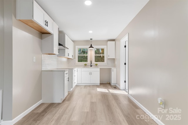 kitchen with white cabinetry, sink, and hanging light fixtures