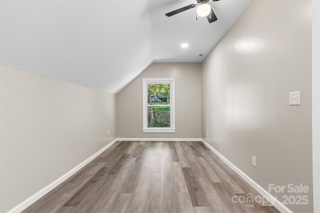 additional living space featuring hardwood / wood-style flooring, ceiling fan, and lofted ceiling