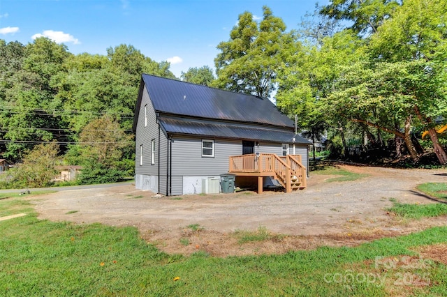 rear view of house featuring a wooden deck