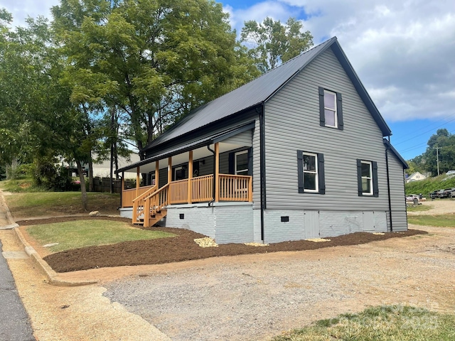 view of side of property featuring covered porch