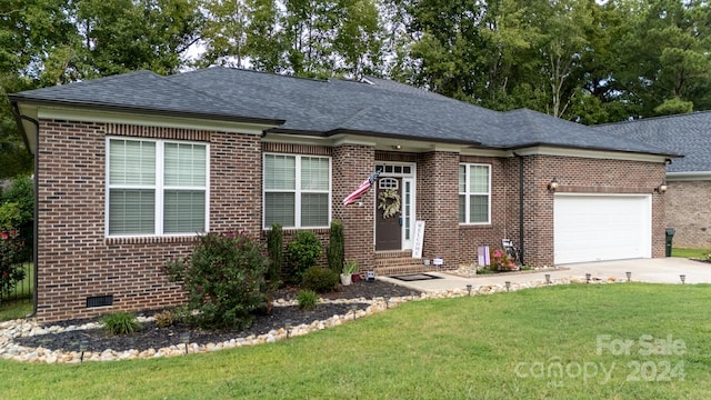 ranch-style home with a garage and a front lawn