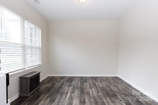 unfurnished room with dark hardwood / wood-style flooring and plenty of natural light