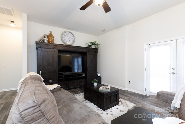 living room with a barn door, ceiling fan, and hardwood / wood-style flooring