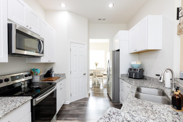 kitchen featuring white cabinets, dark wood-type flooring, stainless steel appliances, and sink