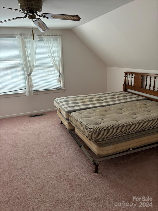 bedroom with ceiling fan, vaulted ceiling, and carpet