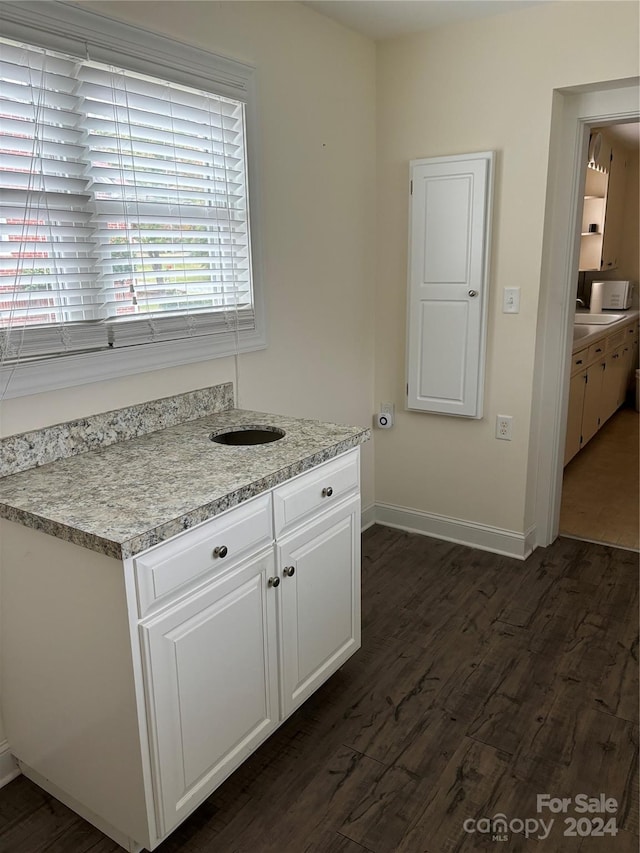 kitchen with dark wood-type flooring and white cabinetry