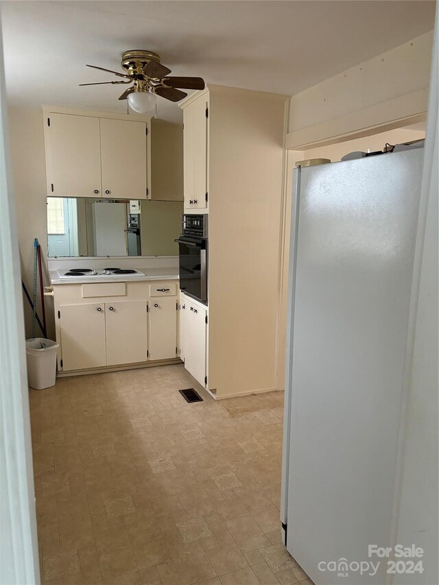 kitchen with white appliances, ceiling fan, and white cabinetry