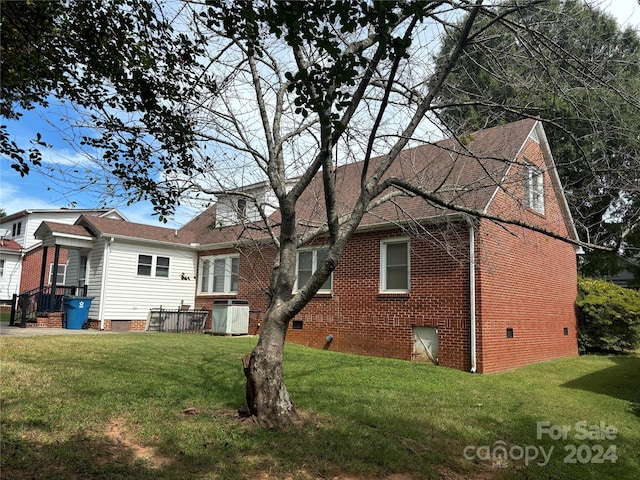 back of property with a yard and central air condition unit