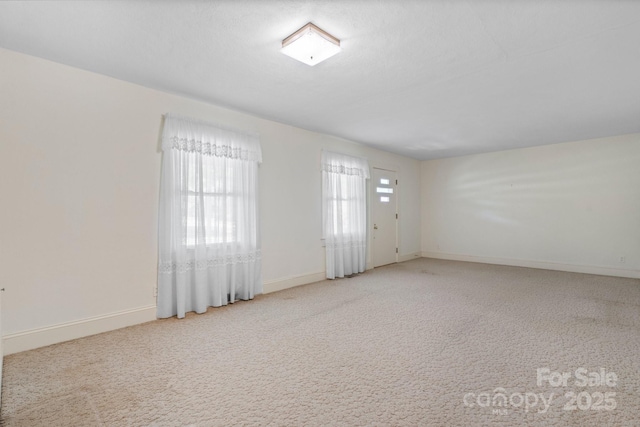 carpeted empty room with baseboards