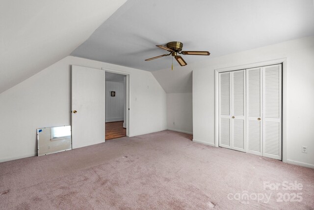 additional living space with vaulted ceiling, carpet, and a ceiling fan