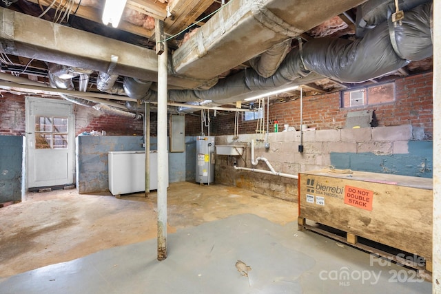 below grade area featuring electric panel, water heater, and fridge