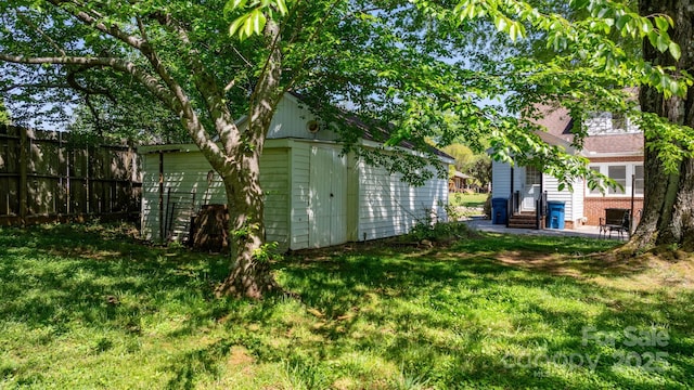 view of yard featuring fence, an outbuilding, and entry steps