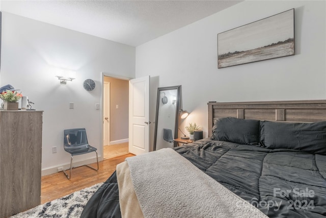 bedroom featuring light wood-type flooring and a textured ceiling