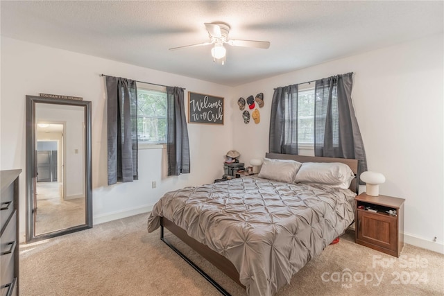 bedroom with light carpet, a textured ceiling, and ceiling fan