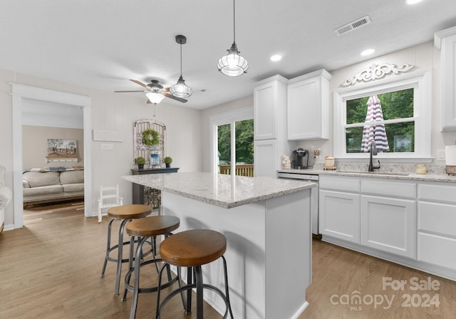 kitchen with plenty of natural light, ceiling fan, sink, and white cabinetry