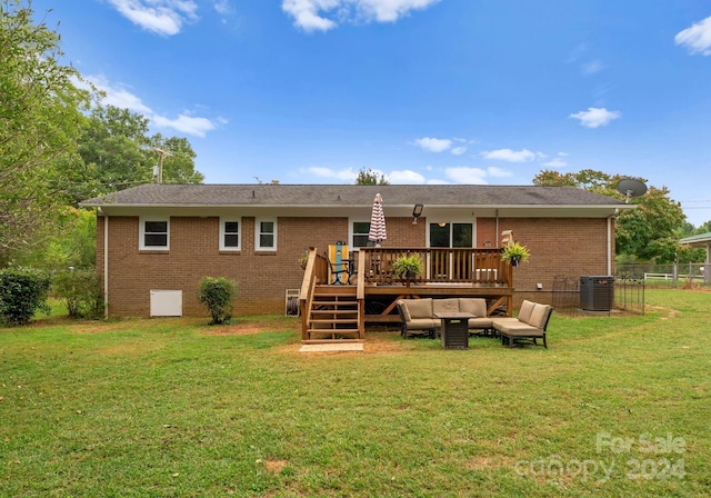 rear view of property with a lawn, a wooden deck, and central AC