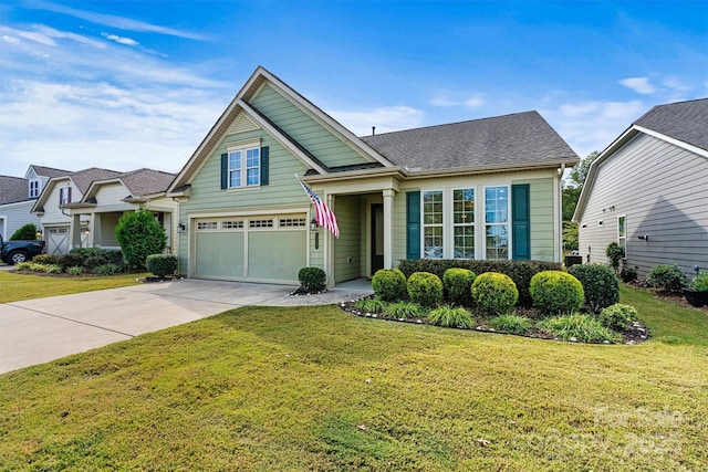 view of front of property with an attached garage, concrete driveway, a front lawn, and a shingled roof