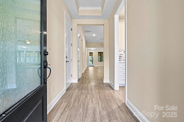 corridor featuring light wood-type flooring, visible vents, and baseboards