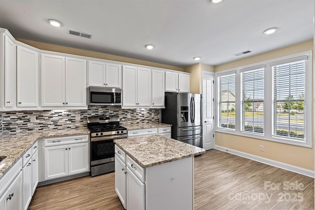 kitchen featuring decorative backsplash, light wood-style floors, visible vents, and stainless steel appliances