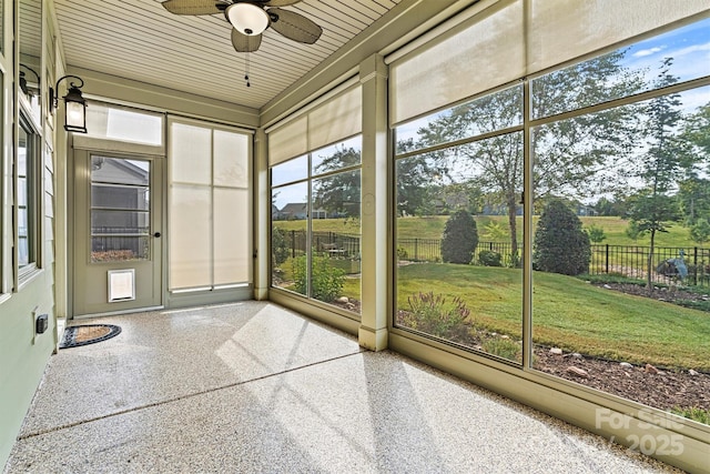 unfurnished sunroom featuring a ceiling fan