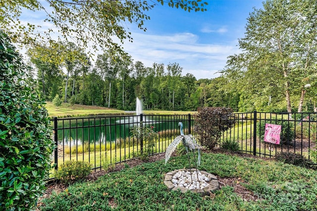 view of yard featuring a water view and fence