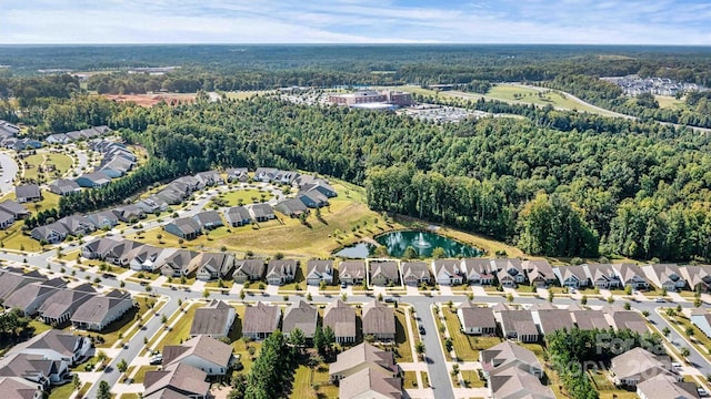 drone / aerial view featuring a residential view, a wooded view, and a water view