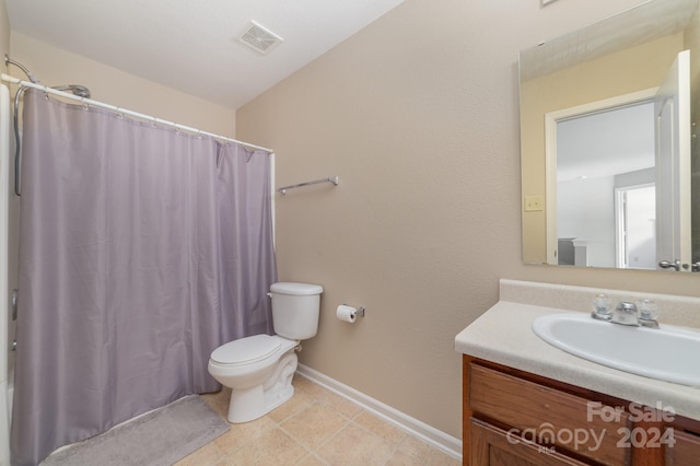 bathroom featuring vanity, toilet, walk in shower, and tile patterned floors