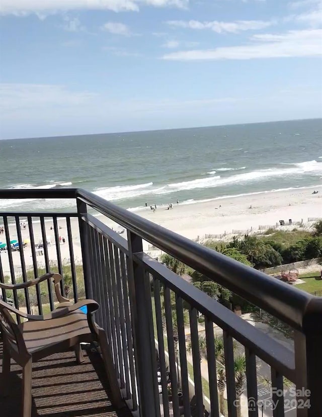 balcony featuring a water view and a beach view