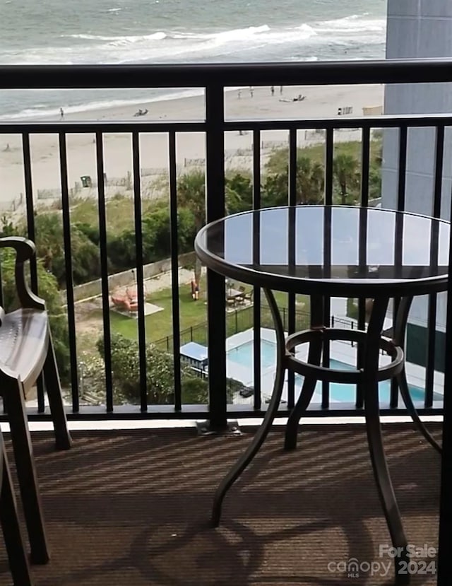 balcony featuring a water view and a beach view