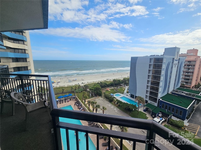 balcony featuring a view of the beach and a water view