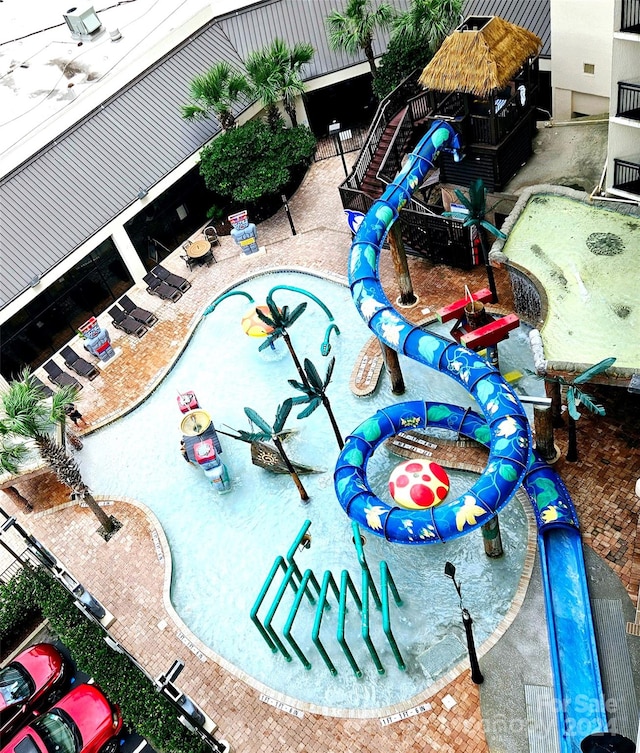 view of swimming pool with a water slide and a patio area