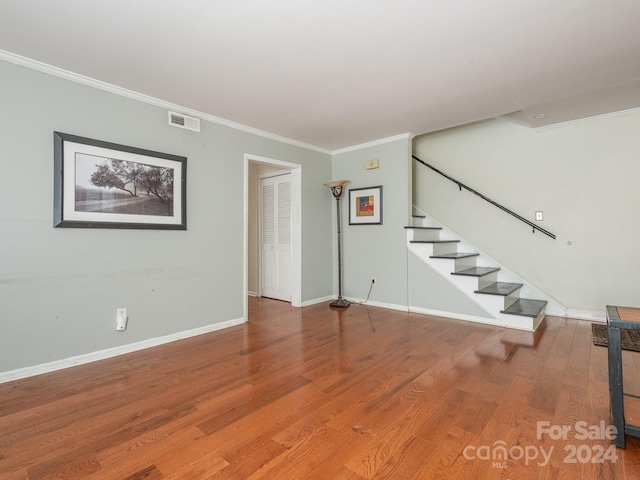 interior space featuring wood-type flooring and crown molding