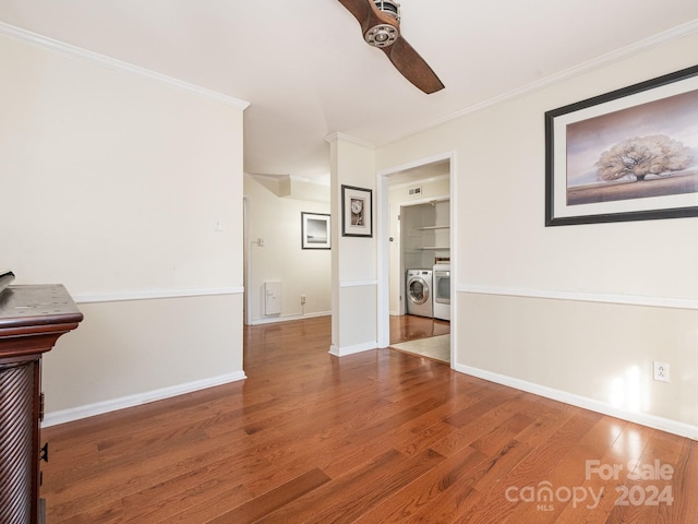 spare room with hardwood / wood-style floors, ceiling fan, washing machine and dryer, and ornamental molding