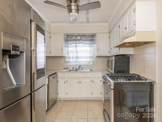 kitchen with white cabinets, appliances with stainless steel finishes, light tile patterned floors, and sink