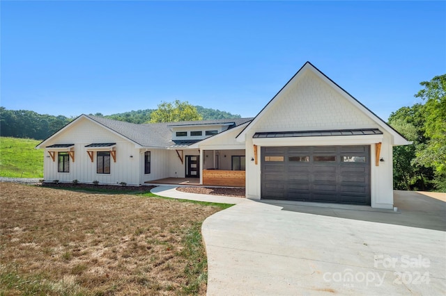 modern farmhouse style home with a front yard and a garage