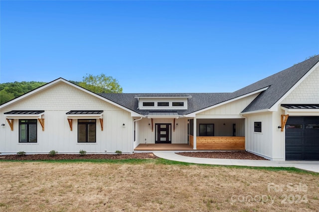 modern farmhouse with a garage and a front lawn