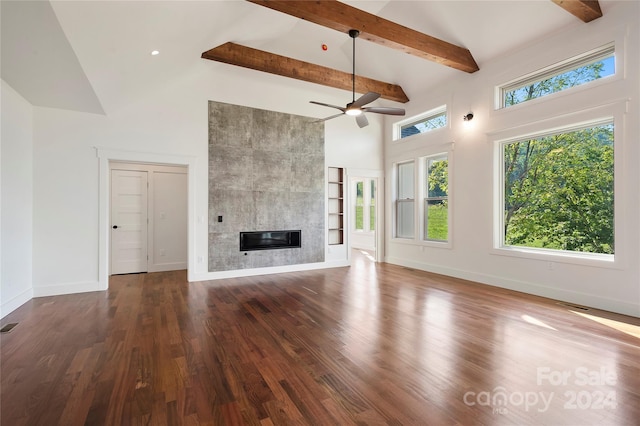 unfurnished living room featuring beam ceiling, a large fireplace, dark wood-type flooring, high vaulted ceiling, and ceiling fan